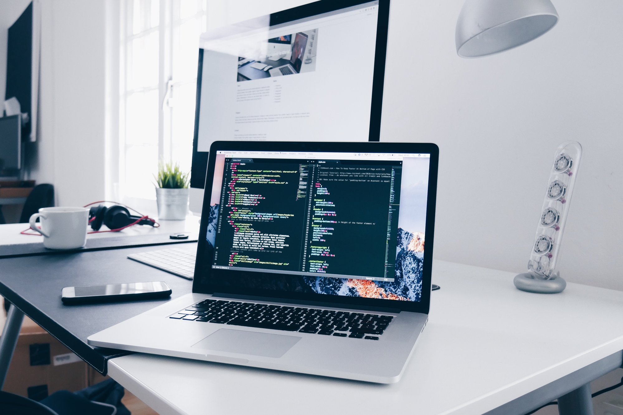 Computer with code on the screen sitting on a desk